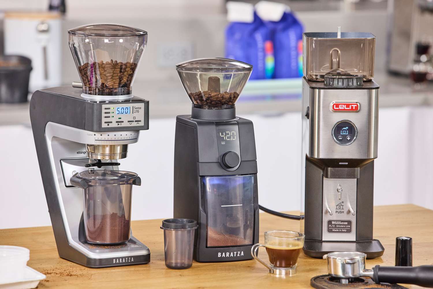 Three espresso grinders on a kitchen counter