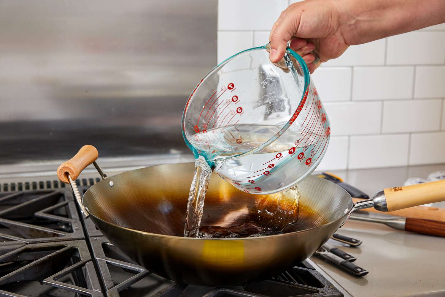 Person pouring water into Joyce Chen Carbon Steel Wok