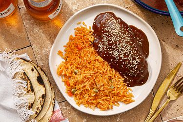 Plate with mole negro and rice served with tortillas on the side