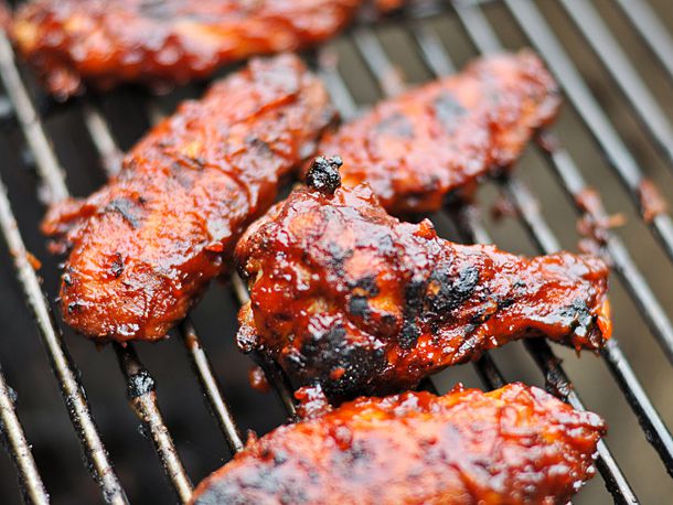 A close-up of habanero barbecued chicken wings on a grill rack.