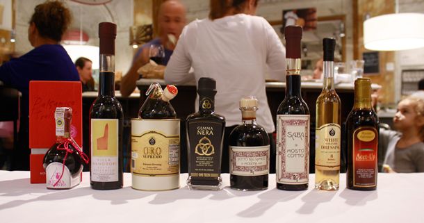 A countertop with eight bottles of different balsamic vinegars at Eataly New York.