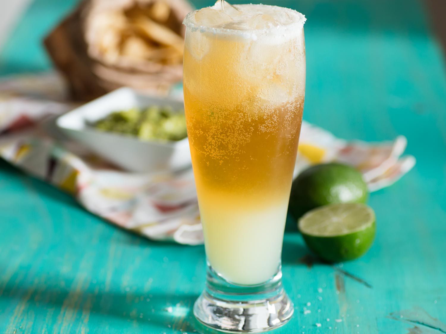 A chelada in a tall, salt-rimmed pilsner glass.