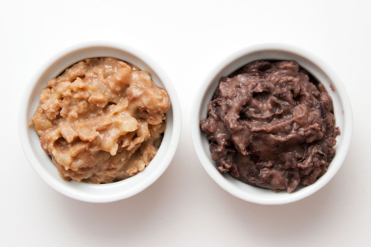 Comparing bowls of refried pinto and black beans