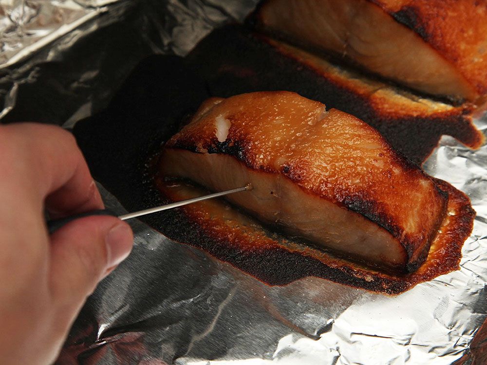 Checking the doneness of the broiled fillets with a cake tester.