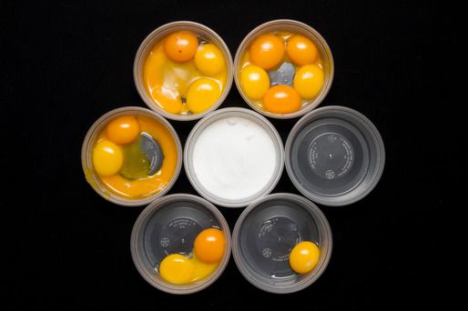 Plastic cups holding different numbers of egg yolks.