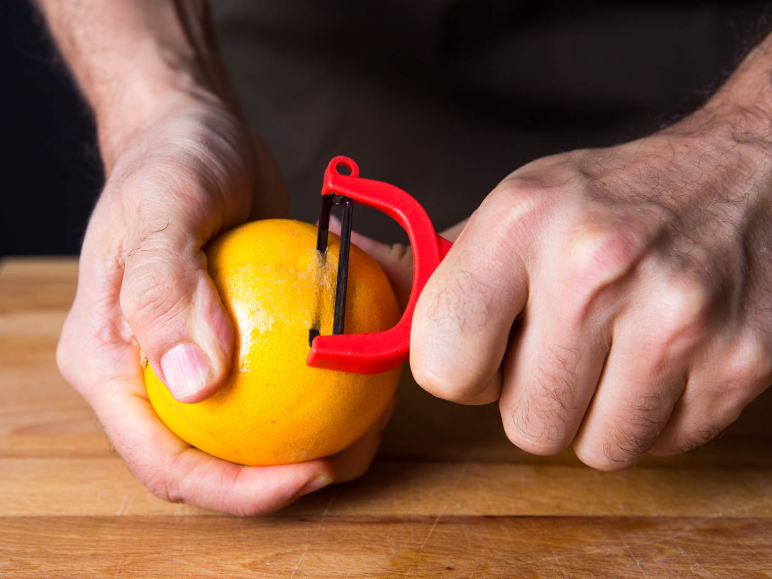 A y-peeler peeling an orange
