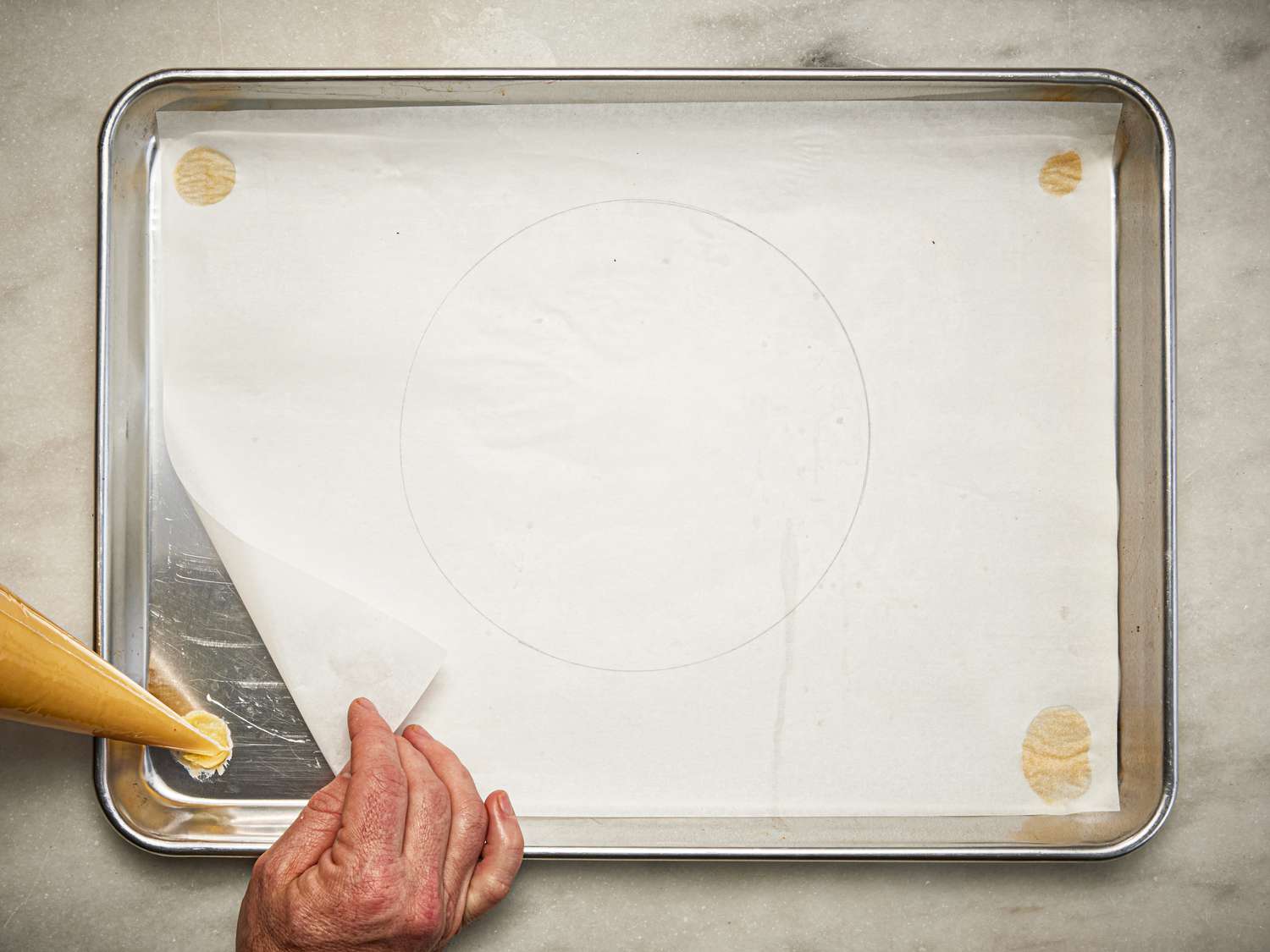 Overhead view of piping choux into sheet tray 