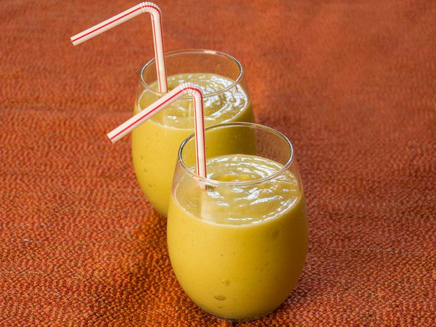 two glasses of Avocado, Mango, and Pineapple Smoothie with drinking straws