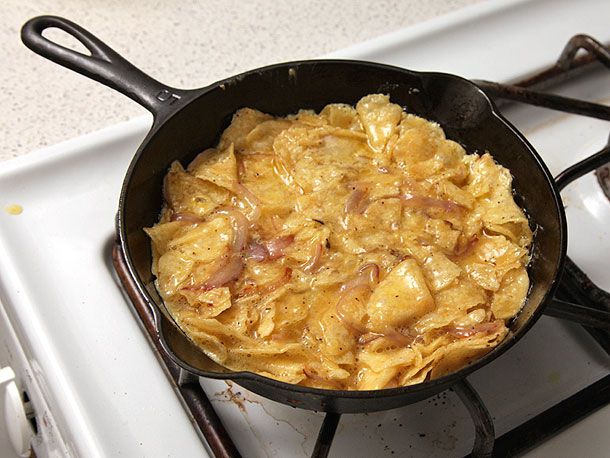 The chip-egg-onion mixture is cooked in the skillet.