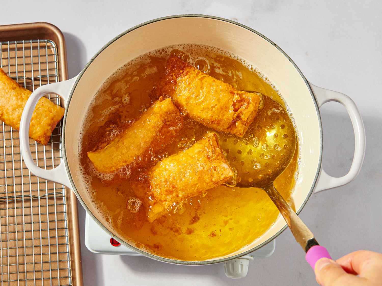Frying hand pies in hot oil using a slotted spoon