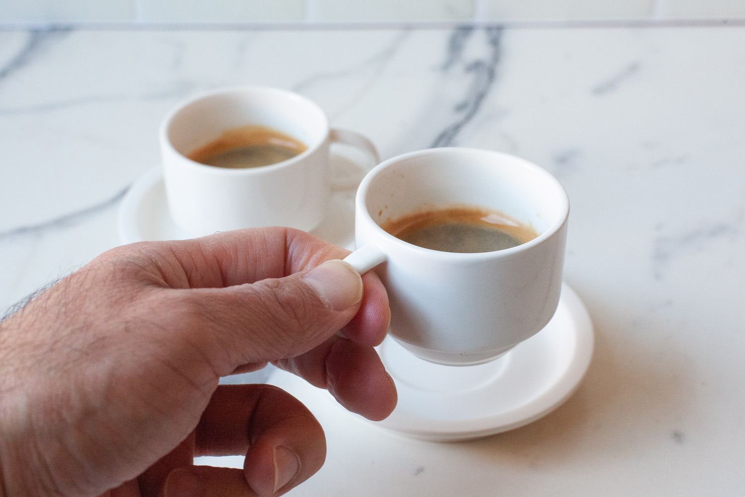 drinking espresso from Sweese Porcelain Stackable Espresso Cups on a marble counter top 