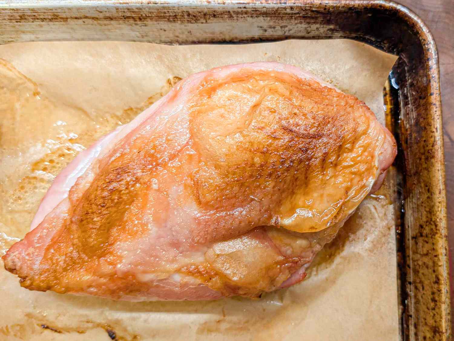 Roasted turkey breast with crispy skin on a parchmentlined baking sheet