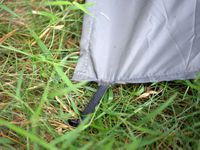 A closeup of the stake on the matador blanket stuck into the grassy ground. 