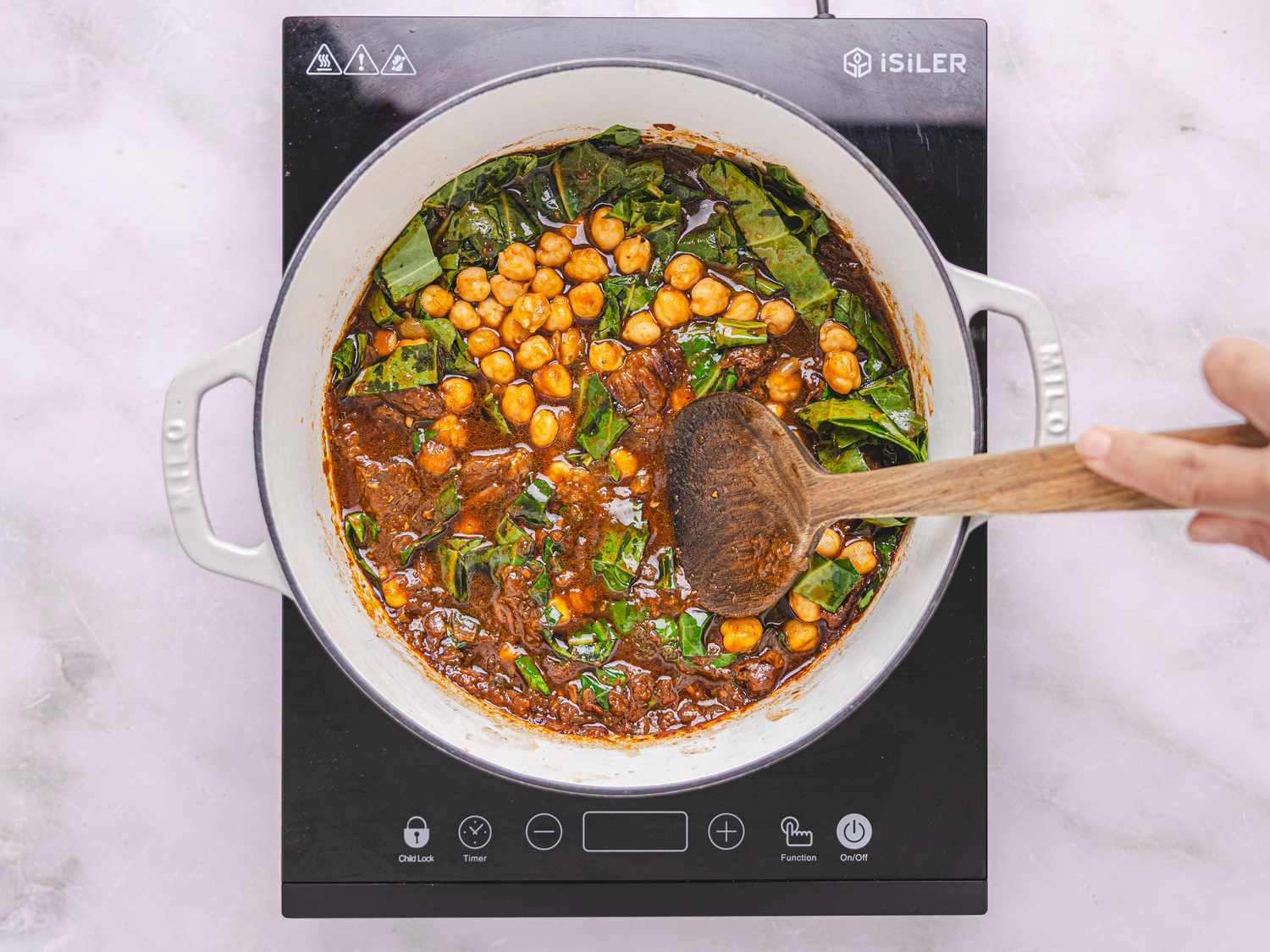 greens and garbanzos added to dutch oven on heat 