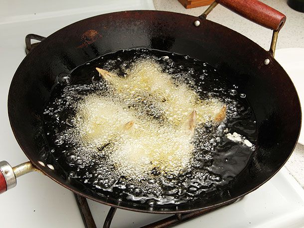 Chicken frying in oil in a wok. 