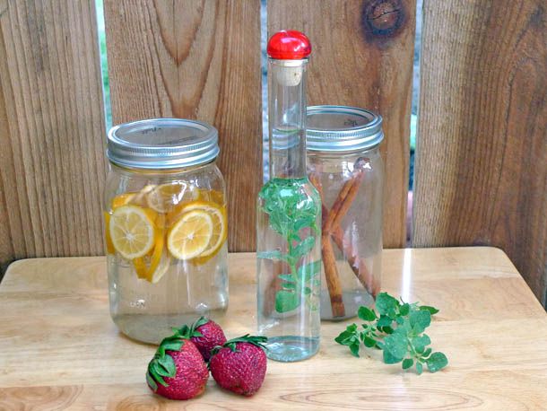 Three jars filled with lemons, mint, and cinnamon and grain alcohol to make infusions. 