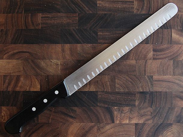 Wüsthof Gourmet 10-Inch Hollow-Ground Roast-Beef Slicer on wood cutting board