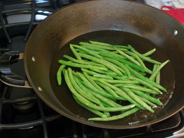 Green beans blanching in a wok full of water