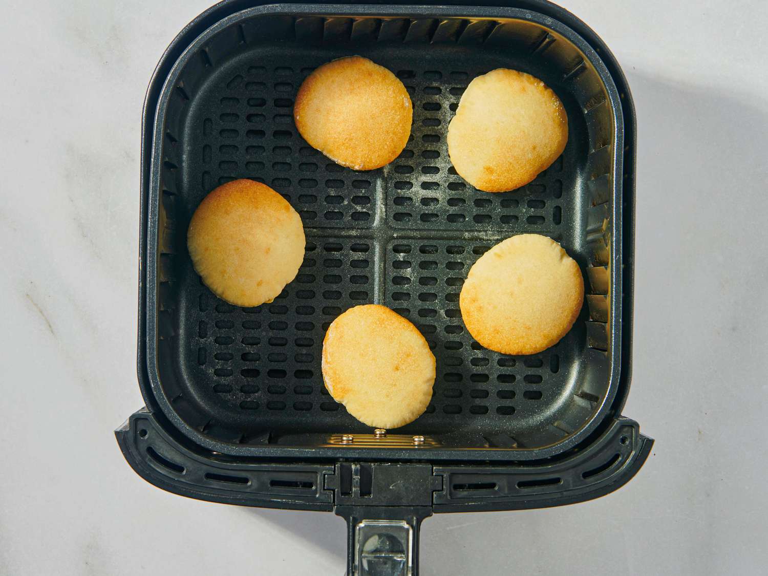 Small pieces of bread or pita in an air fryer basket