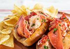 Two lobster rolls overflowing with lobster