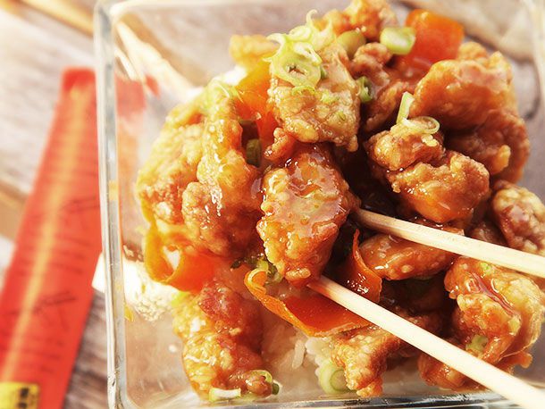 Eating finished orange chicken with chopsticks.