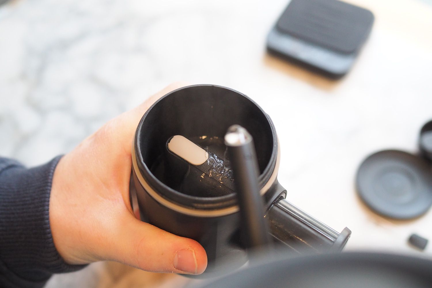 person holding mug while adding water