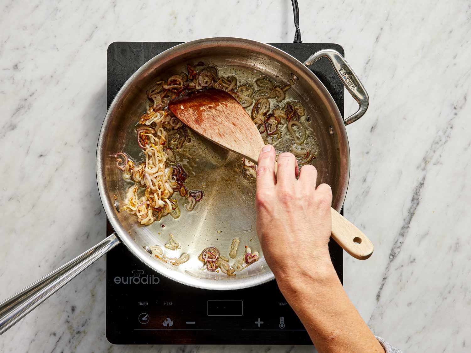 Overhead view of shallots cooking in pot