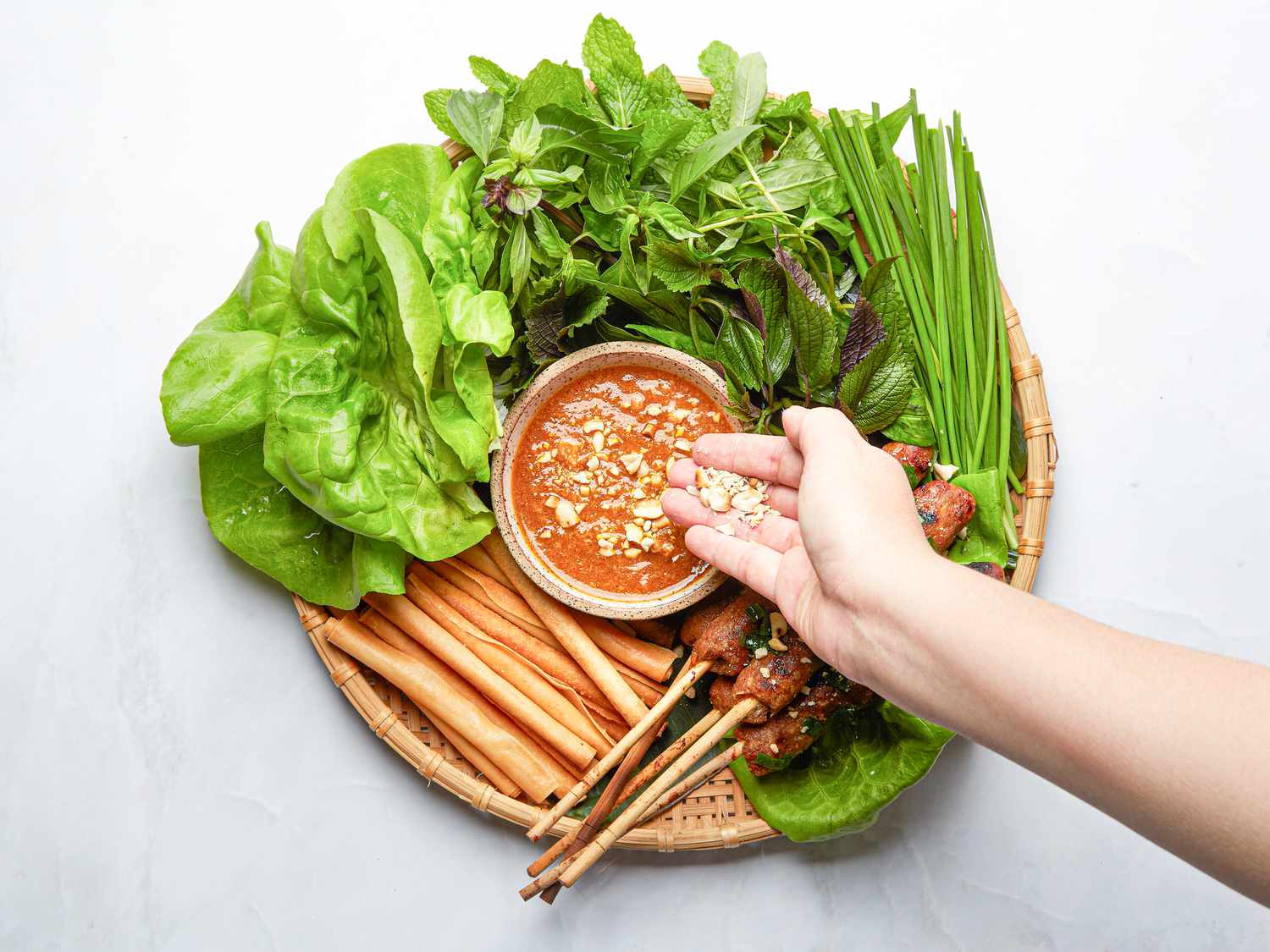 Overhead view of adding peanuts to a dipping sauce