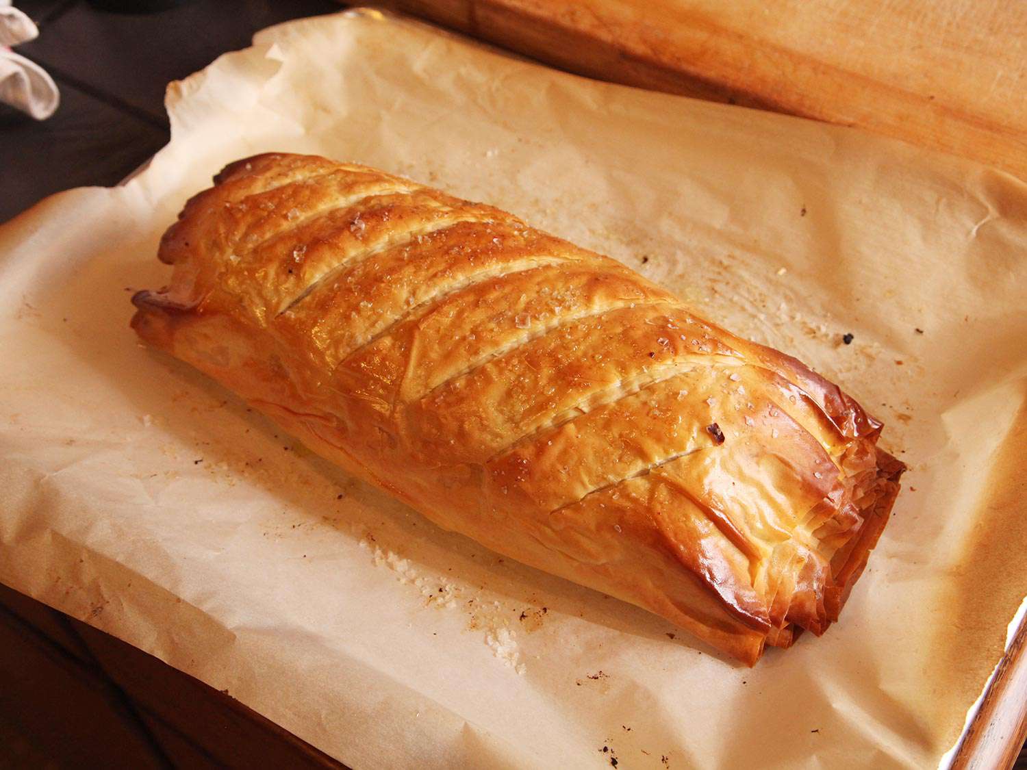 Cooked Vegetables Wellington resting on parchment-lined baking sheet.
