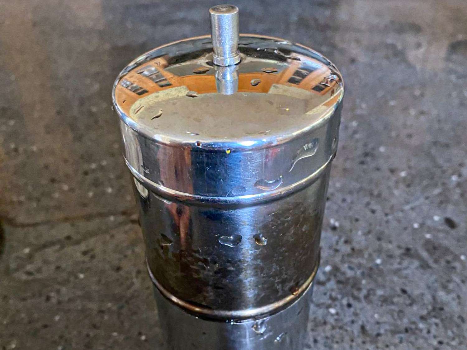 A stainless steel handoperated coffee press on a countertop