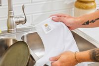 A person holding up a white bar mop.