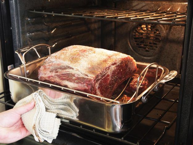 Prime rib in roasting pan going into the oven.