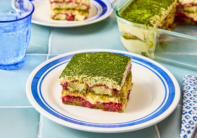 A plate with a slice of strawberry matcha tiramisu set on a table
