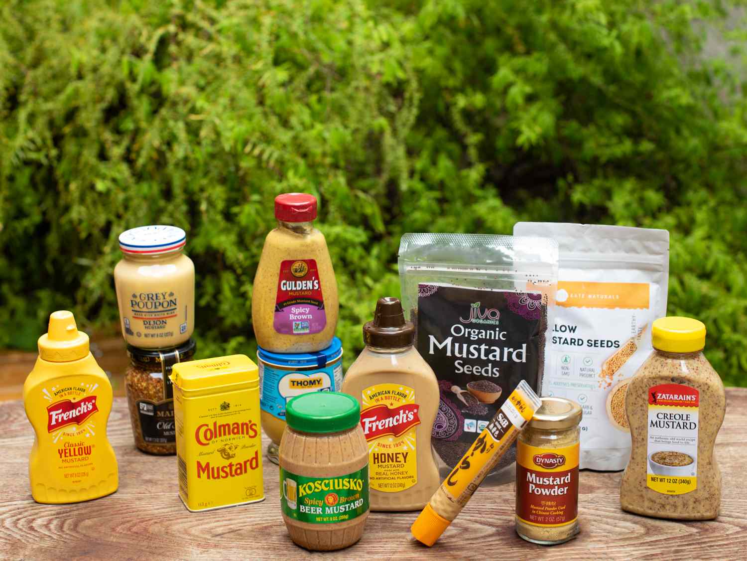a group of mustard products on a table outside in a backyard