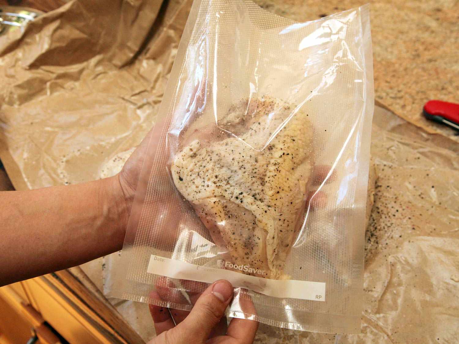 Seasoned chicken breast in a vacuum-seal bag prior to cooking sous vide.