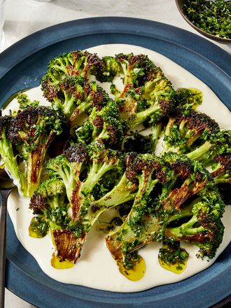 Overhead view of charred broccoli with taleggio cheese sauce