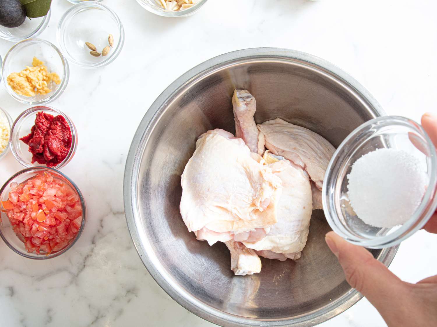 Ingredients including chicken salt and other items laid out for a recipe preparation