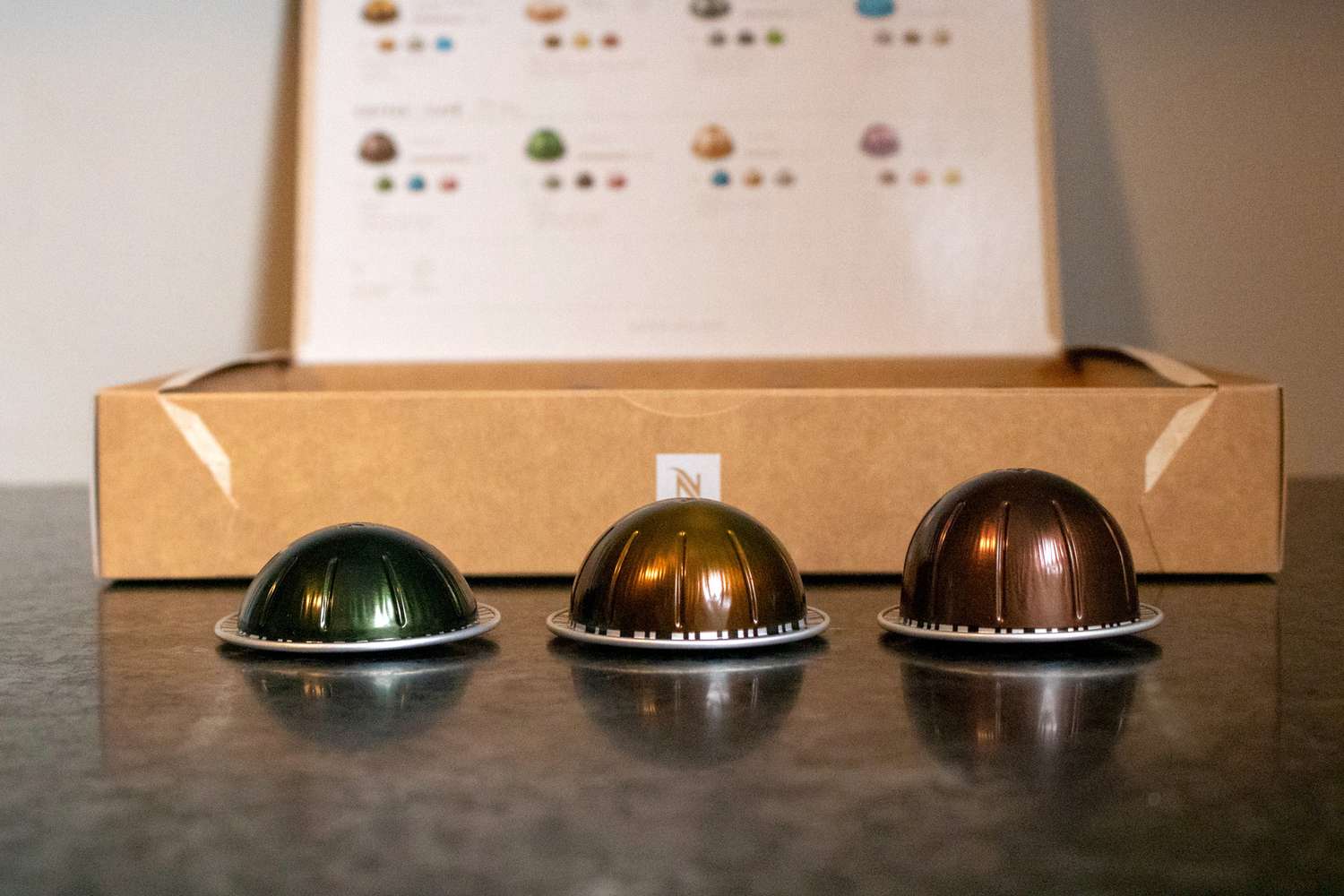 Three different sized Nespresso pods on a kitchen countertop.