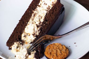 A slice of chocolate ginger peach icebox cake, served with a gingersnap.