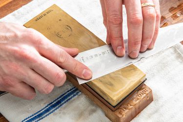 Hands sharpening a knife on a King Fine-Grit Whetstone