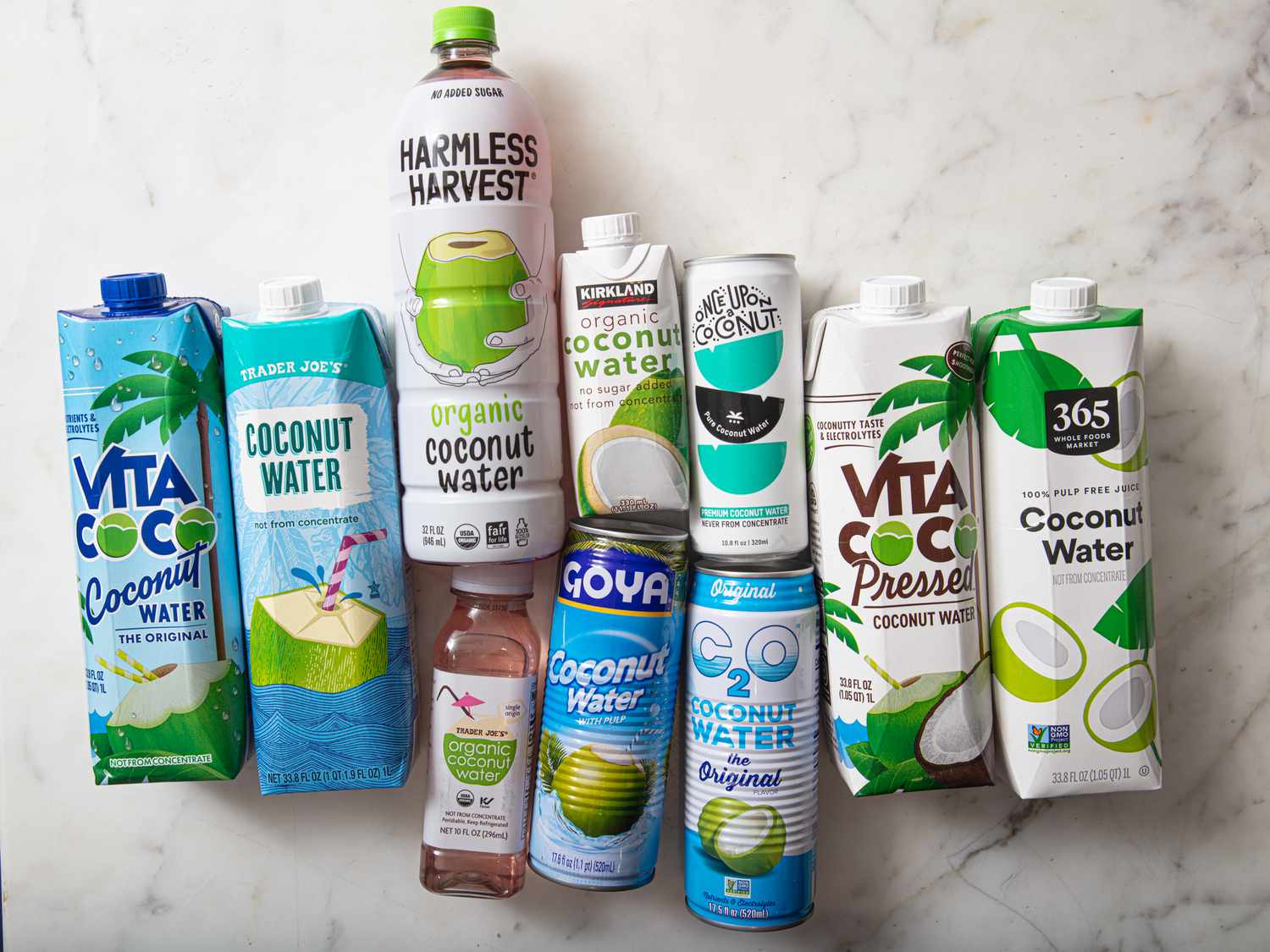 A variety of coconut water brands in cartons and bottles displayed on a surface