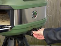 a person adjusting the flame on the gozney tread