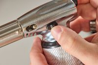 a person unlocking the safety mechanism on the messermeister torch