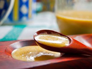 Closeup of a wooden spoonful of lemon drop hit sauce.