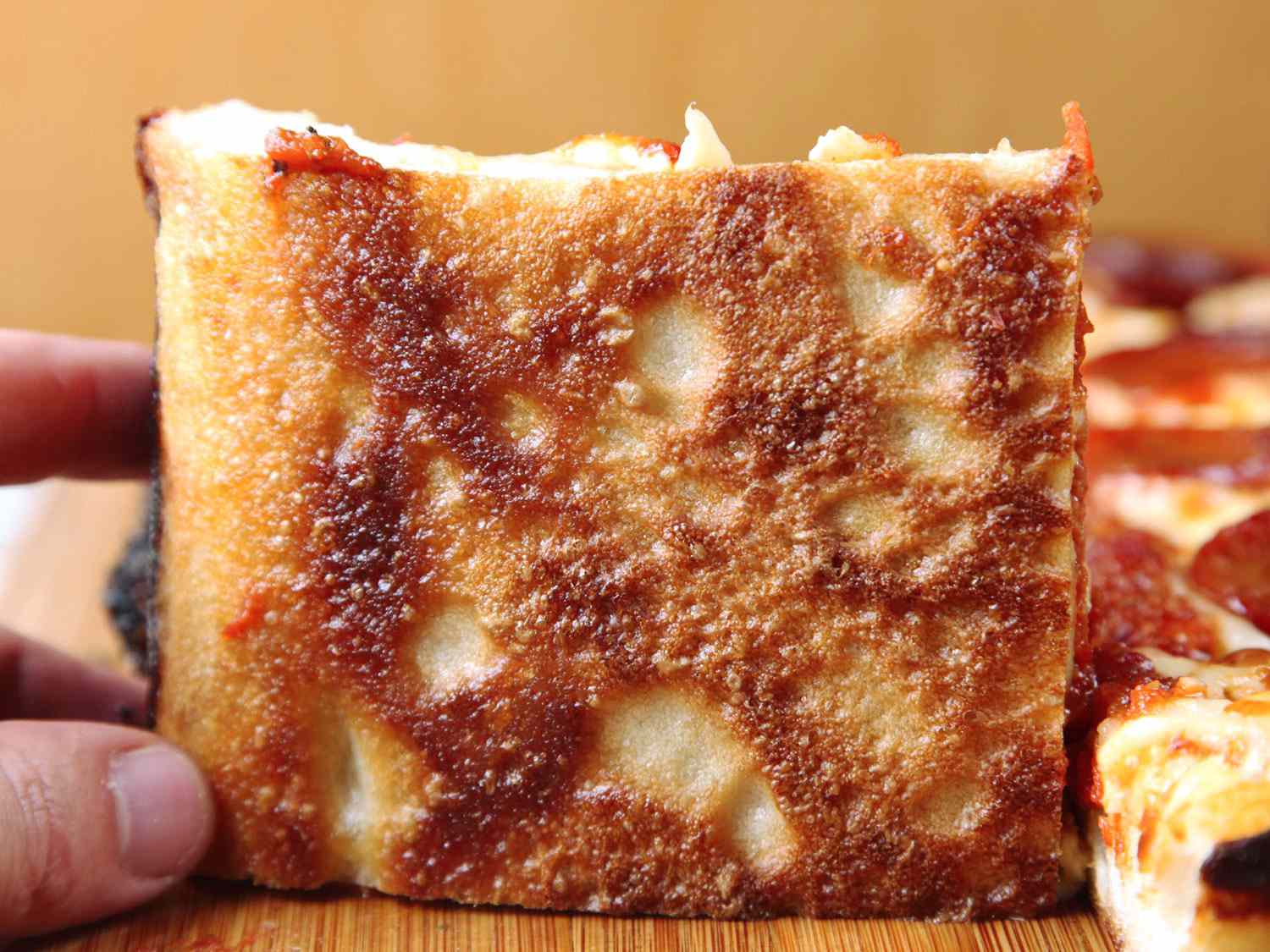 Crisp, browned bottom of a Detroit-style pizza crust.