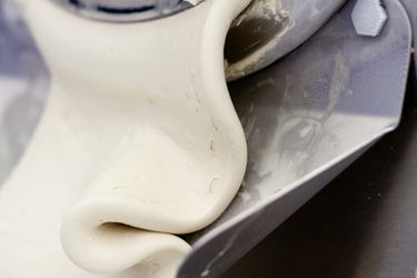 Just churned ice cream being extruded from a small commercial ice cream churn. 