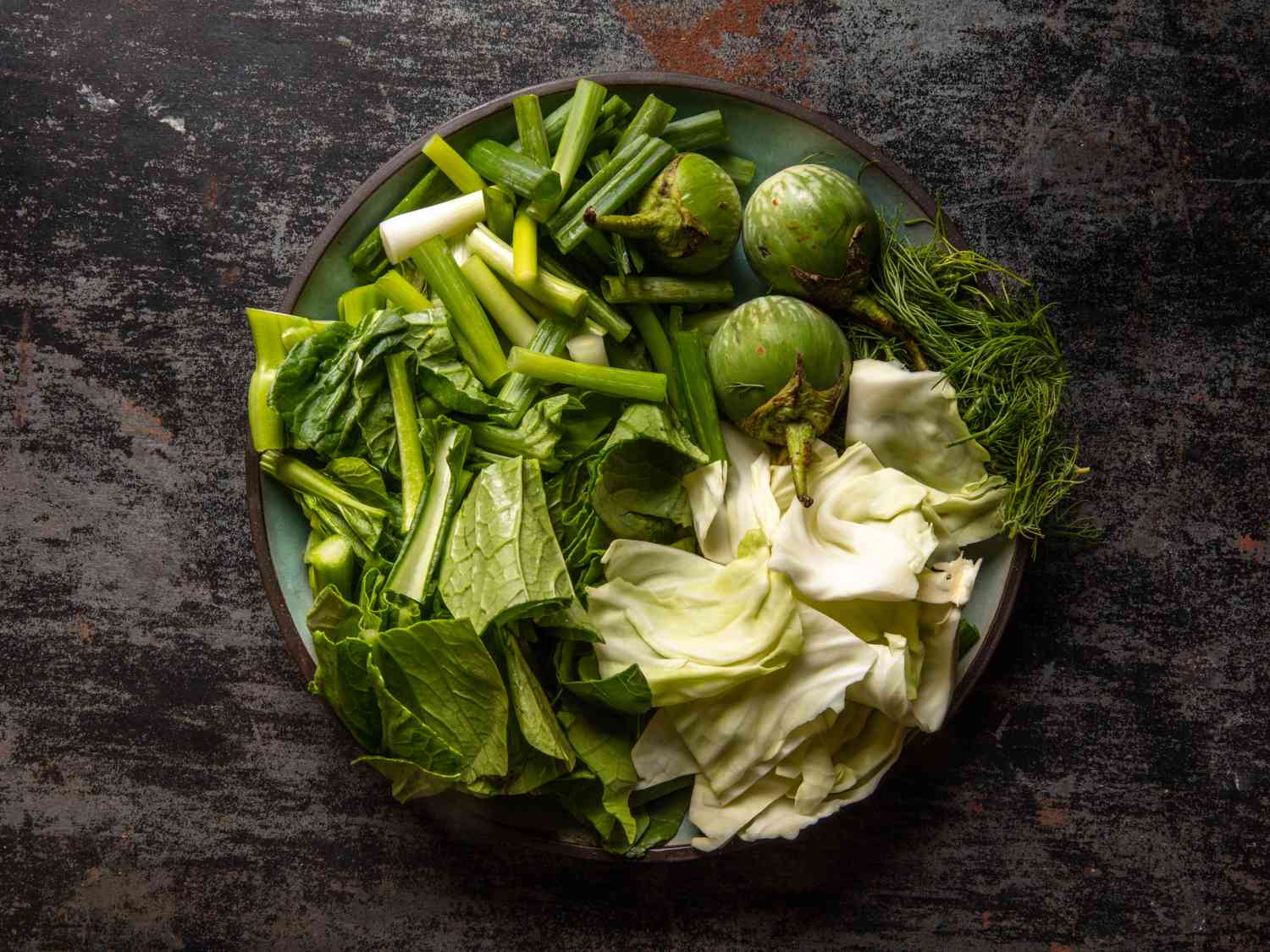a plate of vegetables to use in Gaeng Om Gai (Isan-Style Herbal Curry with Chicken and Dill)