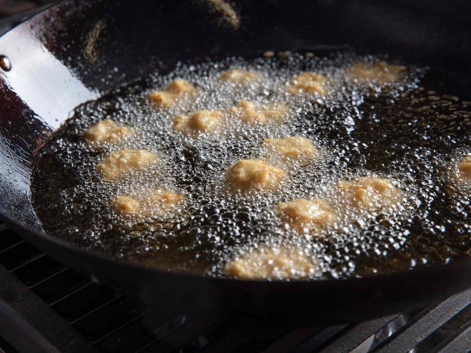 Squid balls frying in a wok.