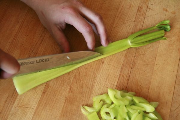 Slicing celery on the bias into bite-size pieces for takeout-style kung pao chicken.