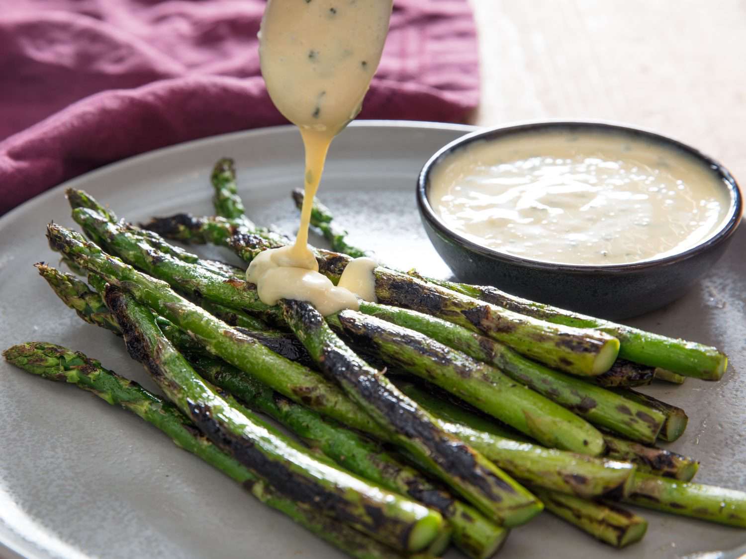 Drizzling miso béarnaise over asparagus.